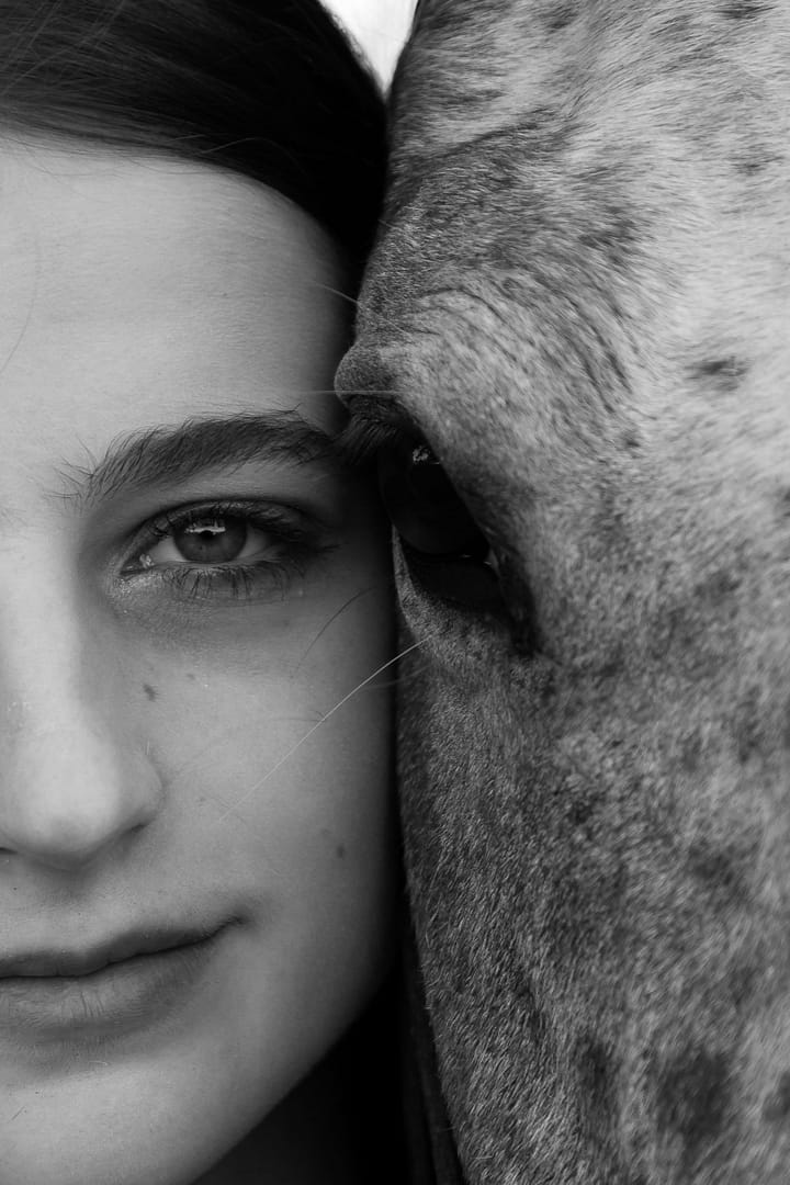 Black and white close up of woman and horse's eyes